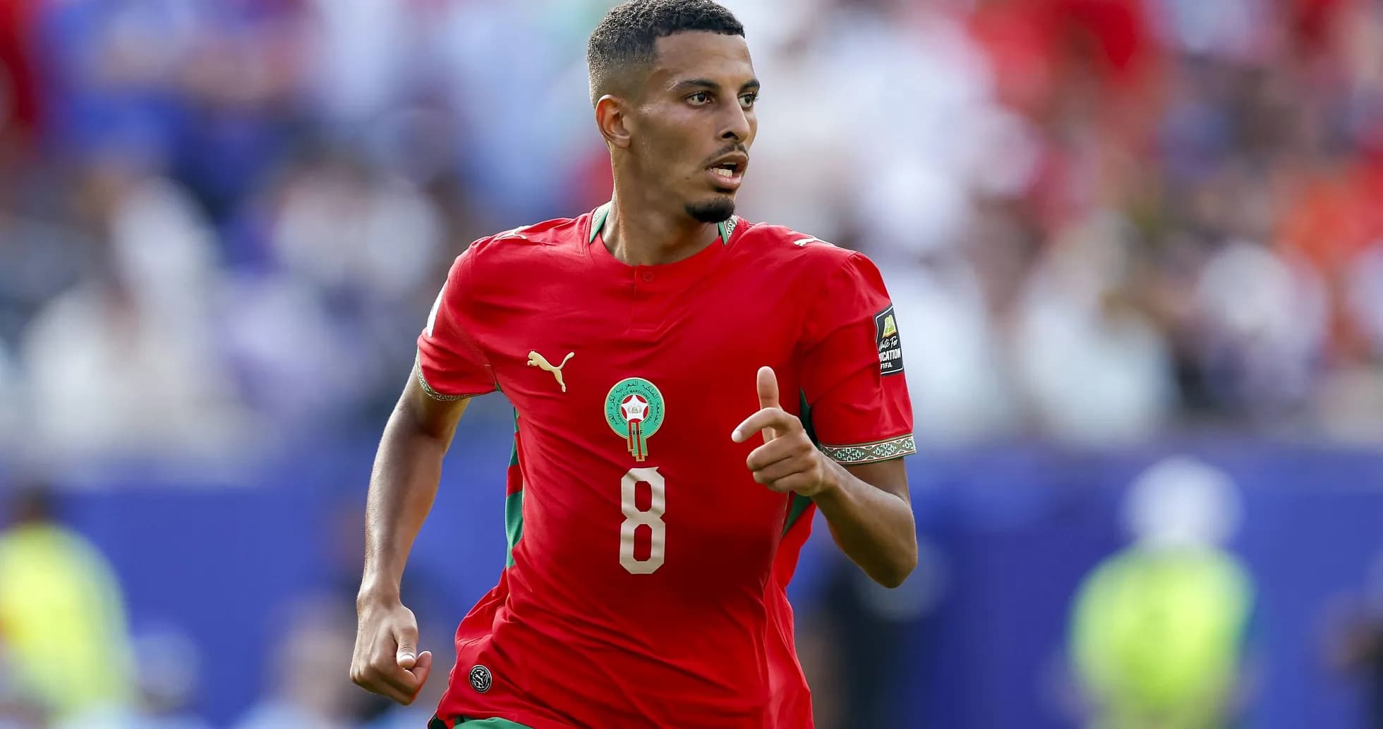 Moroccan player sprinting during a football match Moroccan player sprinting during a football match